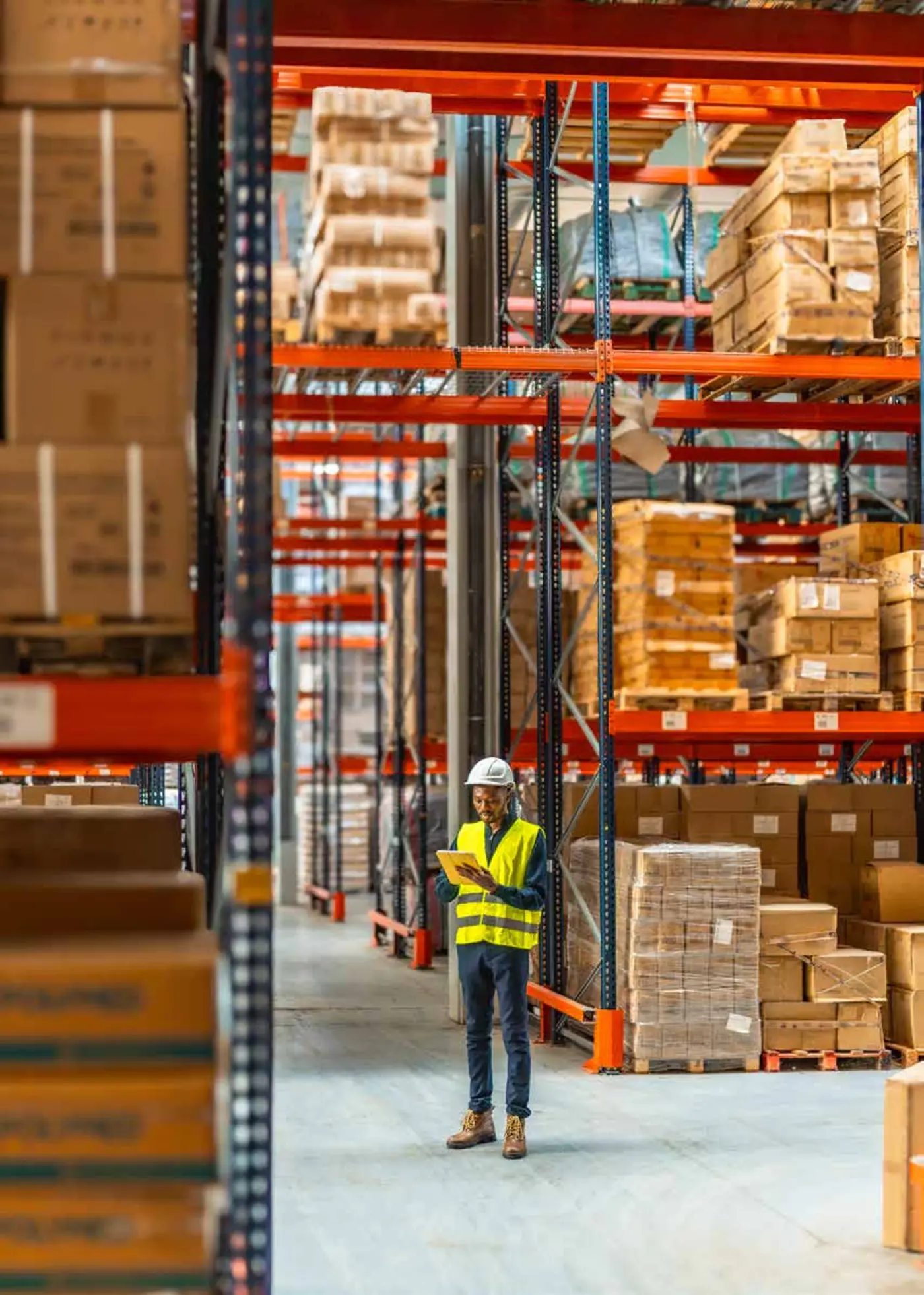 Operatore in un magazzino con scaffalature e pallet